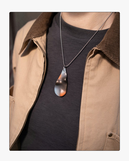 Minimalist umber ceramic teardrop necklace worn on 18 inch silver chain, set against a neutral background