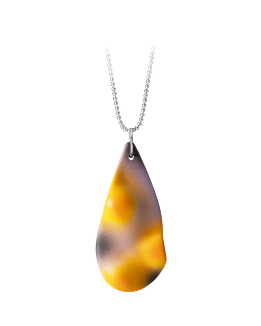 Hand-cast ceramic TOPO Teardrop necklace in Eclipse, featuring a topographic surface with a soft pink and yellow gradient and bold black shadows suspended on a silver ball chain.