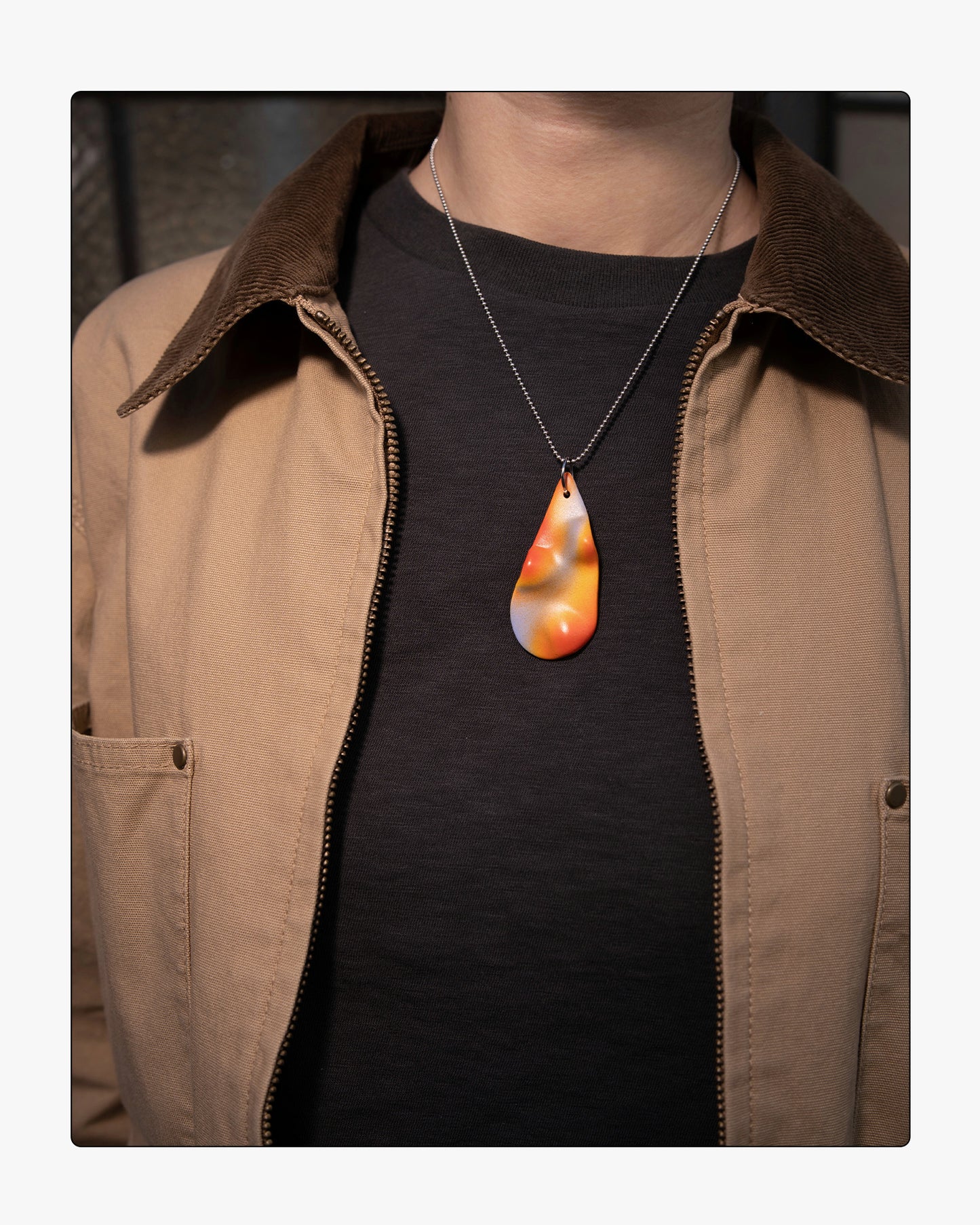 Minimalist Frequency ceramic necklace worn on an 18-inch silver ball chain, showcasing the tactile relief and soft purple and orange tones against a neutral background