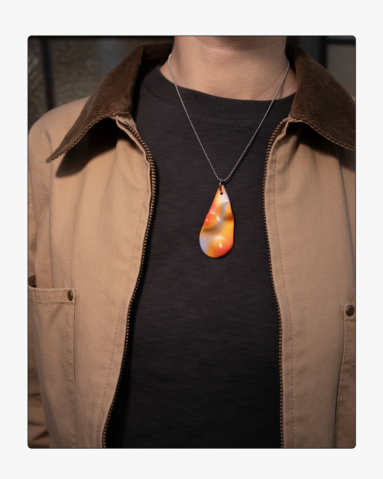 Minimalist Frequency ceramic necklace worn on an 18-inch silver ball chain, showcasing the tactile relief and soft purple and orange tones against a neutral background