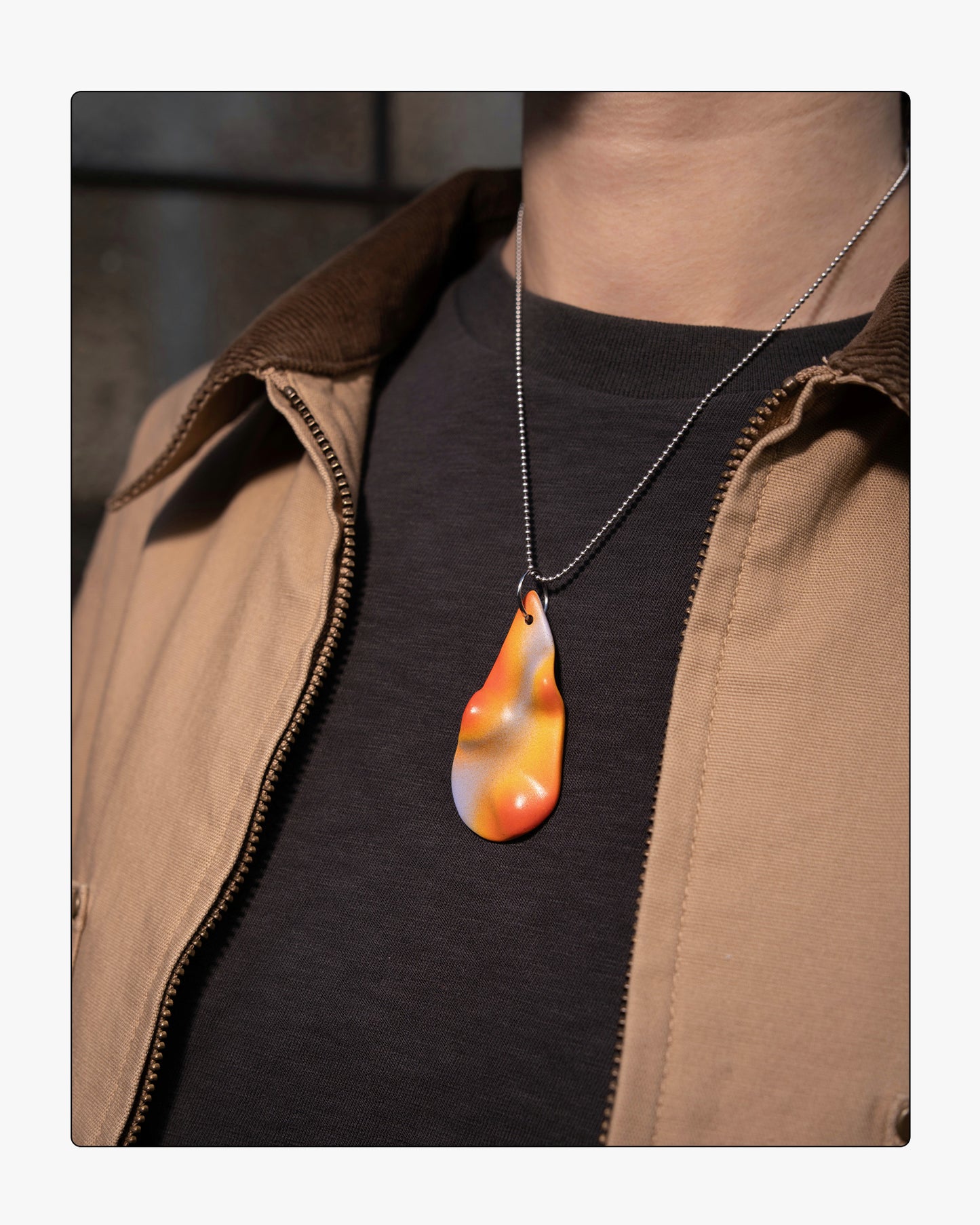 Side view minimalist Frequency ceramic necklace worn on an 18-inch silver ball chain, showcasing the tactile relief and soft purple and orange tones against a neutral background