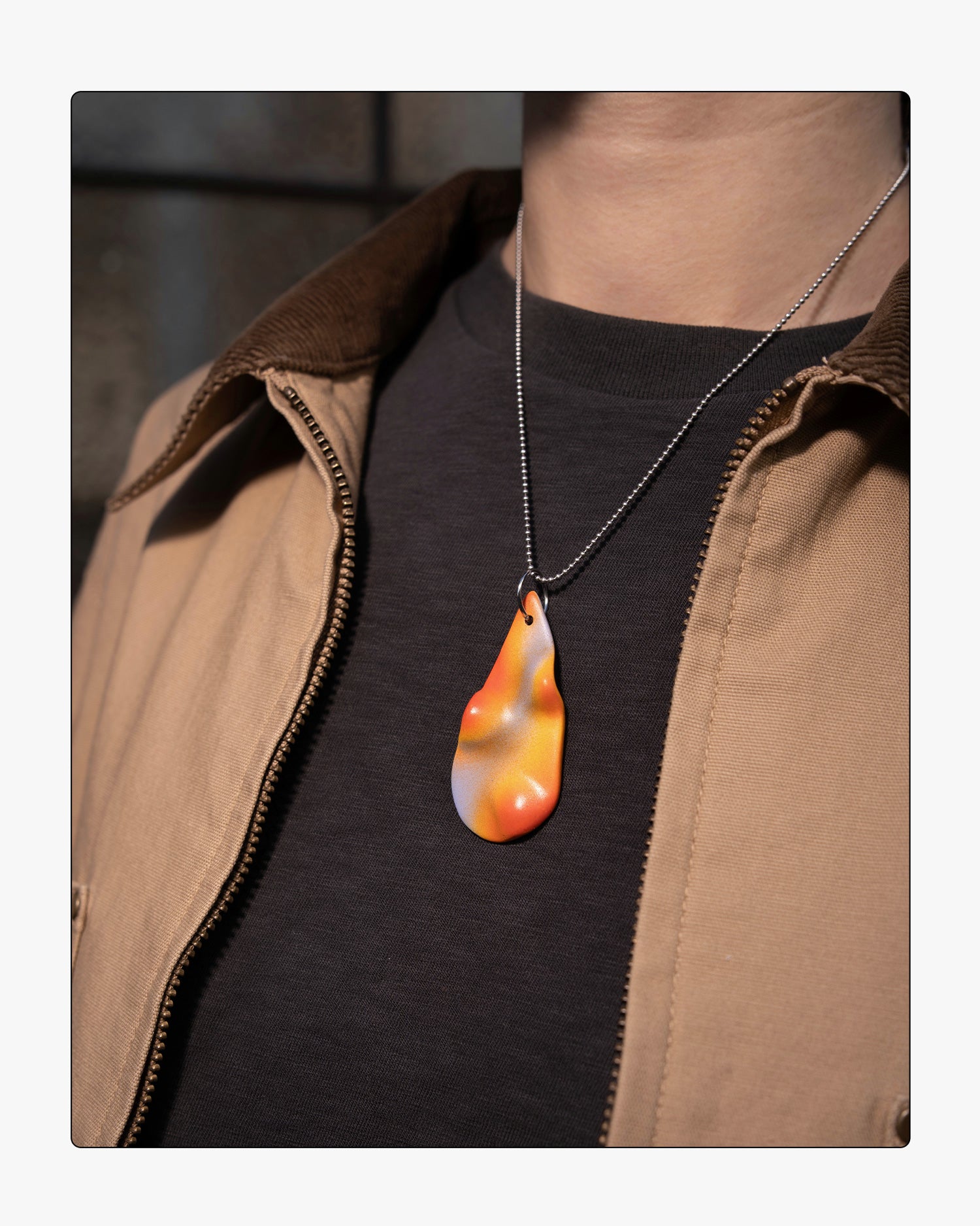 Side view minimalist Frequency ceramic necklace worn on an 18-inch silver ball chain, showcasing the tactile relief and soft purple and orange tones against a neutral background